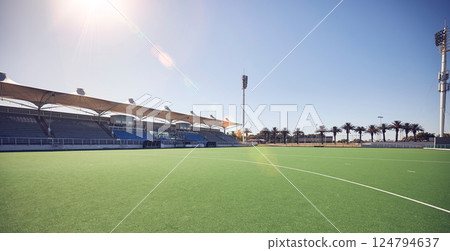 Empty sport field, outdoor grass and training stadium ground in summer ready for sports. Lawn care, sunshine and blue sky by a exercise, workout and game venue isolated and remote for fitness 124794637