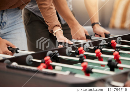 Hands, foosball and table with friends playing a game together indoors for fun or recreation. Football, fun and leisure with a friend group together to play at a party or celebration event 124794746