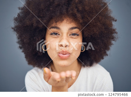 Face, portrait and woman blowing a kiss on a grey studio background being flirty and seductive. Fun, flirting and beautiful african american female kissing and being alluring and isolated on backdrop 124795466