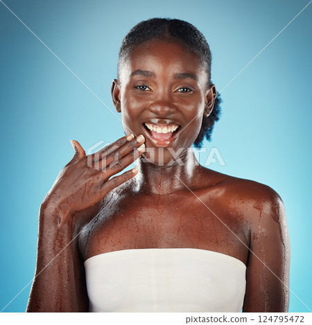 Black woman, skincare beauty and cosmetics wellness touch face for skin happiness. Young African american girl, facial care and smile for luxury skin health lifestyle in blue background studio 124795472