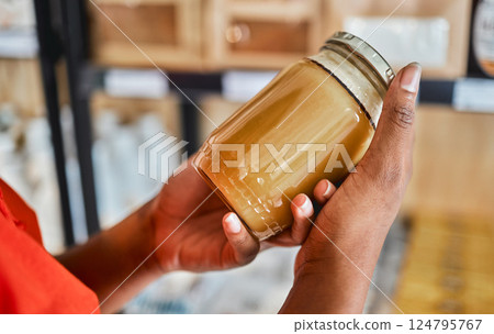 Shopping, peanut butter in hands and grocery store customer decision for sale product, discount or market promotion. Supermarket, groceries and food in glass jar for eco friendly and vegan choice 124795767