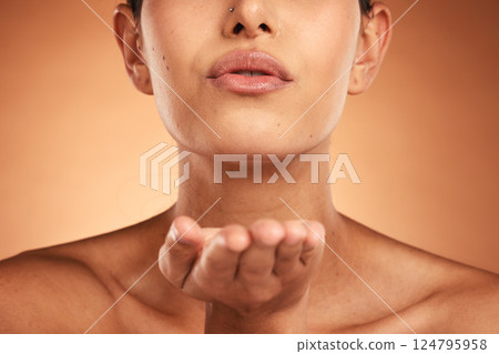 Skincare, beauty and lips of woman in studio for makeup, grooming and kiss, treatment and lipstick on orange background mockup. Facial, hand and kissing girl model satisfied by product and cosmetics 124795958