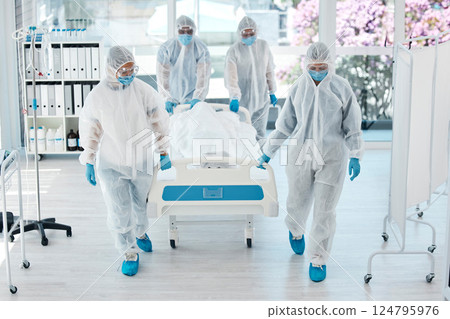 Covid, ppe and doctors with patient stretcher in hospital for quarantine or testing. Health, safety and medical workers in hazmat suits pushing bed in clinic after death of person with covid 19. 124795976