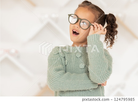 Child, girl or kid and fashion glasses, vision eye frame or medical healthcare eyes prescription in optometry clinic. Eye care lens, insurance or optician eyeglasses for youth with wow or amazed face 124795985