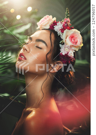Face, beauty and flowers with a model woman in studio on a natural forest background for wellness or skincare. Nature, luxury and cosmetics with an attractive young female in a rainforest or jungle 124796057