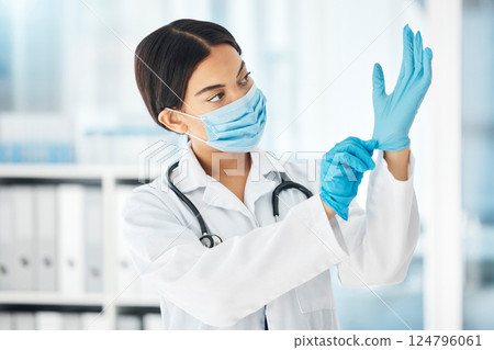 Healthcare, covid and a doctor putting gloves on hands, woman ready for check up examination or surgery in hospital or clinic. Safety, protection and lady medical worker with surgical face mask. 124796061