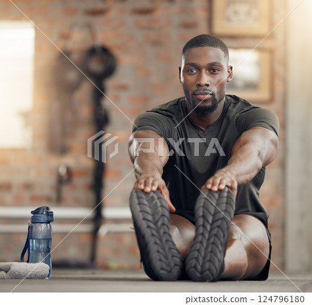 Black man, stretching and fitness in gym workout, training and exercise with health goals, motivation or wellness target. Bodybuilder, sports athlete or personal trainer in warmup for muscle relief 124796180