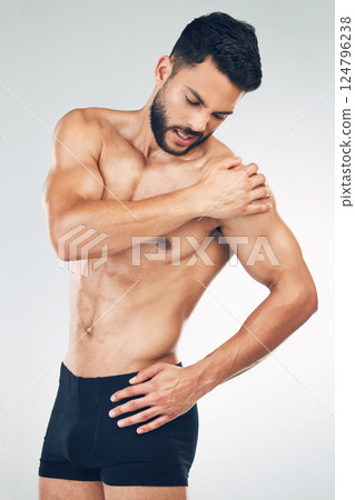 Shoulder pain, injury and fitness man in underwear in mockup studio background. Inflammation, hurt muscle and a male model with muscular body in holding his arm, health and body care after workout Shoulder pain, injury and fitness man in underwear in mockup studio background. Inflammation, hurt muscle and a male model with muscular body in holding his arm, health and body care after workout 124796238