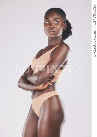 Beauty, body and underwear with a model black woman in studio on a gray background for natural health or wellness. Lingerie, skin and fitness with an attractive young female posing arms crossed alone 124796250