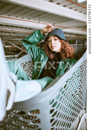 Fashion, parking lot and shopping cart portrait of woman student relaxing with edgy, trendy and carefree style at mall. City, young and urban fashionista girl in Mexico resting in customer trolley. 124796331