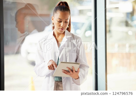 Healthcare, doctor and black woman with tablet in hospital looking at diagnosis, report and online. Technology, innovation in medical care and woman standing by window in clinic with digital notebook 124796576
