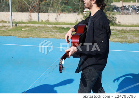 Boy Plays Guitar Music At A Private Concert In The Countryside 124796796