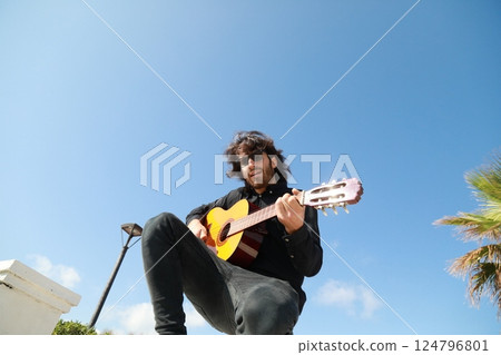 Man Plays Classical Guitar On A Day Stand In The Park 124796801