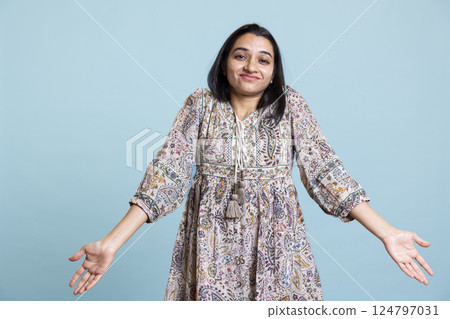 Bewildered confused girl raising her shoulders and being unaware of something, acting clueless and doubtful to answer an ambiguous question. Indian uncertain puzzled woman in studio. Bewildered confused girl raising her shoulders and being unaware of something, acting clueless and doubtful to answer an ambiguous question. Indian uncertain puzzled woman in studio. 124797031