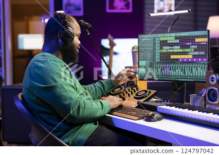 Talented engineer using an usb stick to edit recorded files in home studio, working on music post production. Young audio technician adding sound effects on mixing console and pc interface. 124797042