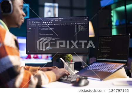 African american computer scientist in home office programming code on pc. Freelancing developer solving tasks for an IT job, writing lines of code at his personal office, cybersecurity. African american computer scientist in home office programming code on pc. Freelancing developer solving tasks for an IT job, writing lines of code at his personal office, cybersecurity. 124797165