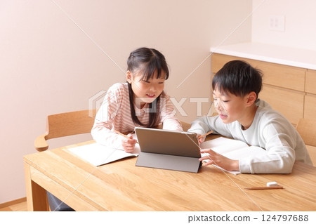 Elementary school boys and girls studying on tablets 124797688