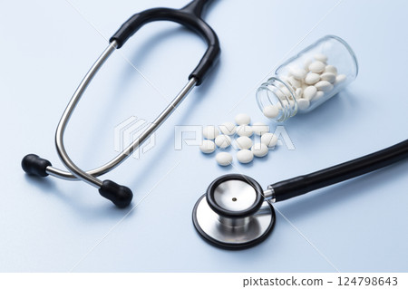 聽診器和藍色背景上的藥丸 124798643