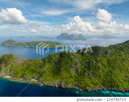 View of Inambuyod with blue sea from Matinloc Island. Blue sky clouds. El Nido, Philippines. 124798724