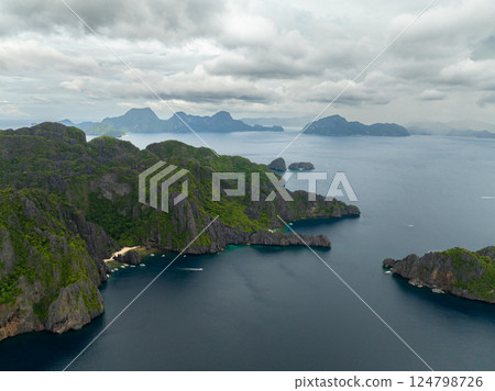 Miniloc Island surrounded by blue sea with boats. Lagoon and Beach in El Nido, Philippines. 124798726
