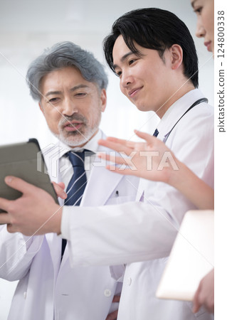 Image of team doctors, supervising doctor and trainee doctor checking medical records and examination status Image of team doctors, supervising doctor and trainee doctor checking medical records and examination status 124800338