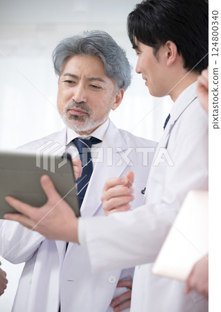 Image of team doctors, supervising doctor and trainee doctor checking medical records and examination status Image of team doctors, supervising doctor and trainee doctor checking medical records and examination status 124800340