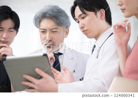 Image of team doctors, supervising doctor and trainee doctor checking medical records and examination status Image of team doctors, supervising doctor and trainee doctor checking medical records and examination status 124800341