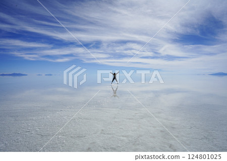 A woman jumps into the mirror-like Uyuni Salt Flats 124801025