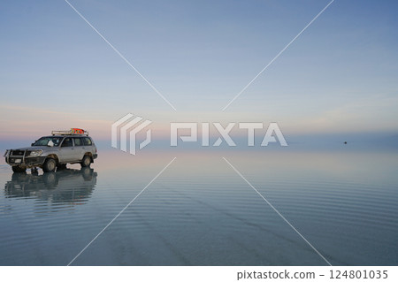 Car driving at sunrise on the Uyuni Salt Flats 124801035