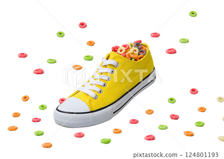 A bright yellow sneaker filled with colorful cereal, isolated on white A bright yellow sneaker filled with colorful cereal, isolated on white 124801193
