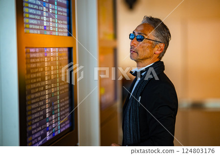 A man checking in at the airport terminal A man checking in at the airport terminal 124803176
