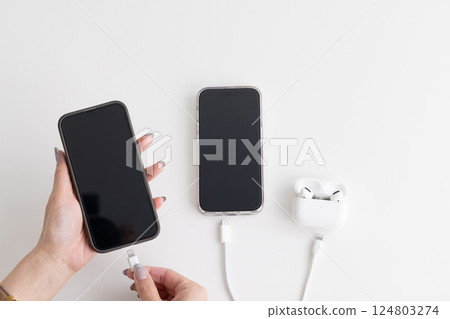 Hands plugging in a smartphone charger 124803274