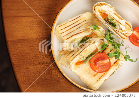 Wrap sandwich grilled with feta cheese on a plate. Copy space. Top view 124803375