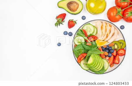 Fresh green salad with grilled chicken fillet, tomatoes, avocado, lemon on light background. Diet Concept. Top view copy space, 124803433