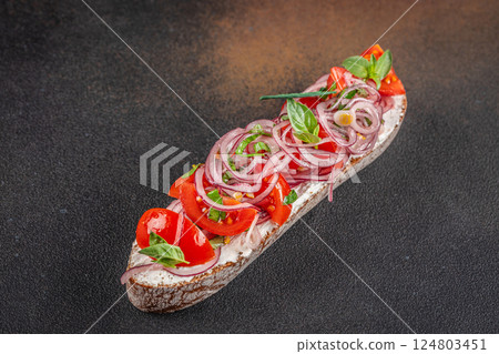 delicious Italian Tomato Bruschetta with herbs and oil on toasted garlic cheese bread on a dark background. top view. copy space for text 124803451