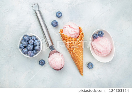 ice cream vanilla gelato and fresh berries. blueberry and waffle ice cream cones on a light background, top view ice cream vanilla gelato and fresh berries. blueberry and waffle ice cream cones on a light background, top view 124803524