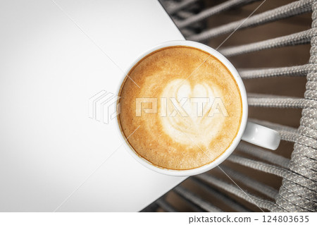 Hot coffee latte or cappuccino spiral foam in ceramic cup on white background, top view 124803635
