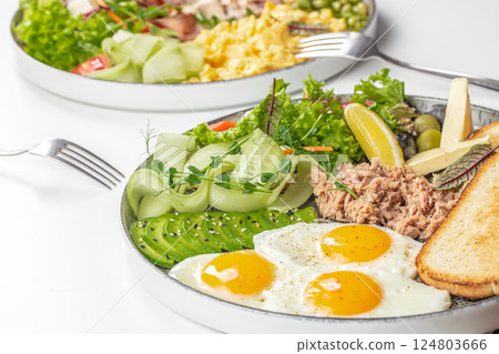assortment of tasty breakfast platter with eggs and assorted dishes on Table 124803666