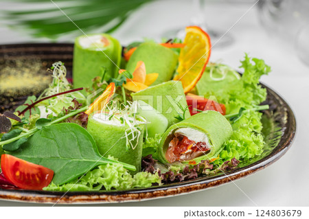 Spinach pancakes rolled with salted salmon and soft cheese 124803679