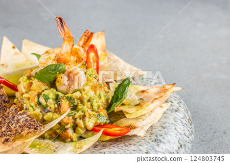 guacamole and shrimp served with crispy tortilla chips. Food recipe background. Close up 124803745