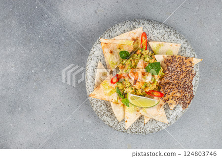 delicious guacamole, nachos chips and shrimp on a light background, top view. copy space. Classic Tex-Mex restaurant appetizer 124803746