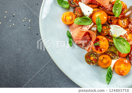 prosciutto salad, cherry tomatoes, and cream cheese with basil leaves, antipasto, Restaurant menu, dieting, cookbook recipe top view 124803758