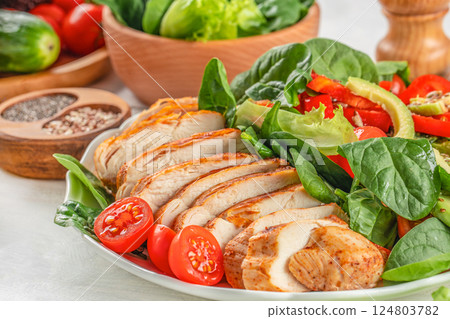 Roasted chicken breast, fillet and fresh vegetable salad. Food recipe background. Close up Roasted chicken breast, fillet and fresh vegetable salad. Food recipe background. Close up 124803782