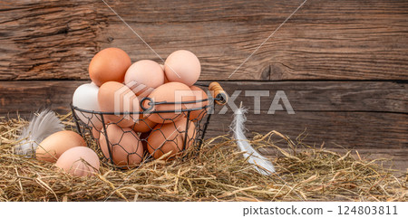 basket of fresh chicken eggs on wooden table. eco poultry farm, free range chicken farm. Long banner format. copy space 124803811