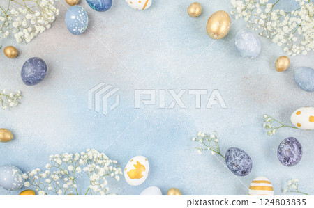 Festive Easter background. Easter eggs and flowers on a blue table. top view. copy space 124803835