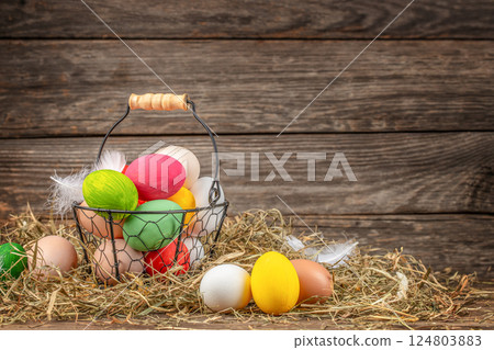 basket of Easter eggs farmer collects eggs at eco poultry farm on a wooden background basket of Easter eggs farmer collects eggs at eco poultry farm on a wooden background 124803883