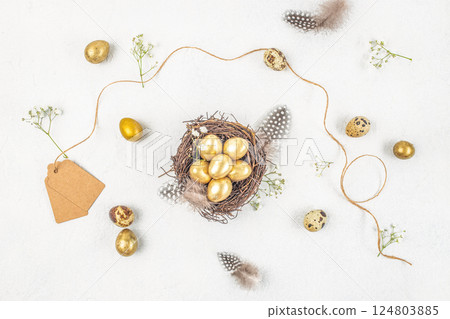 Easter quail eggs, nest and flowers on white background. Easter festive greeting card. Top view 124803885