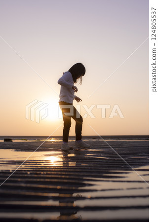 A girl walking along the sunset path at Matama Beach 124805537