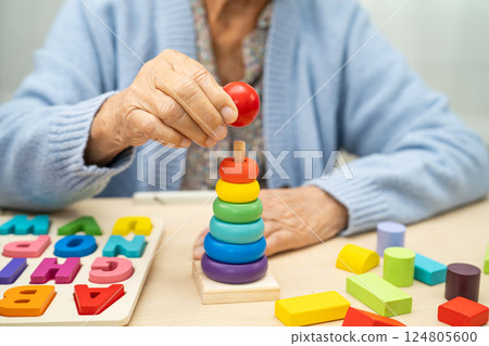Alzheimer disease AD, Asian elderly woman patient suffering from dementia learn practical motor skills rehabilitation. 124805600