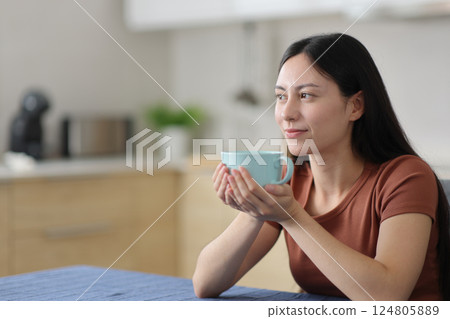 Asian woman looking away holding coffee cup 124805889